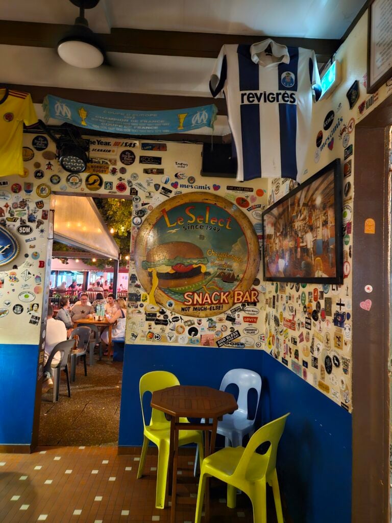 The iconic green and yellow exterior of Le Select bar in Gustavia, St. Barth—the home of the Cheeseburger in Paradise.